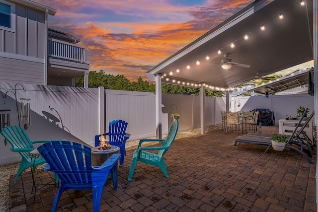 135 Grayling Way, Inlet Beach, FL 32461 - patio terrace at dusk with a fenced backyard, a fire pit, ceiling fan, a patio, and outdoor dining space