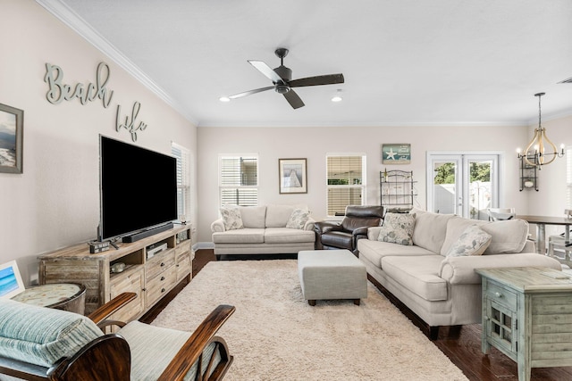 living room featuring french doors, ceiling fan with notable chandelier, crown molding, and dark wood-type flooring