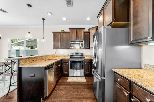 kitchen featuring ornamental molding, stainless steel appliances, sink, dark hardwood / wood-style floors, and a breakfast bar area