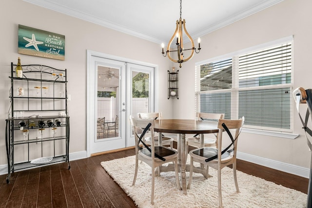 dining room featuring dark hardwood / wood-style floors, ornamental molding, a chandelier, and french doors