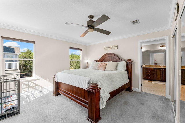 carpeted bedroom with ceiling fan, crown molding, connected bathroom, and multiple windows