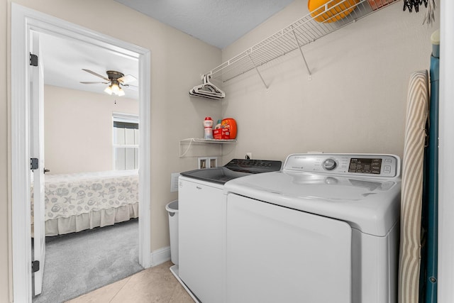 clothes washing area featuring separate washer and dryer, ceiling fan, light tile patterned floors, and a textured ceiling