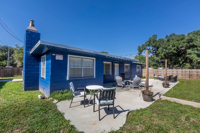 back of property with a patio area and a yard