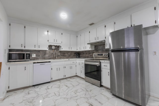 kitchen featuring white cabinets, appliances with stainless steel finishes, tasteful backsplash, and sink