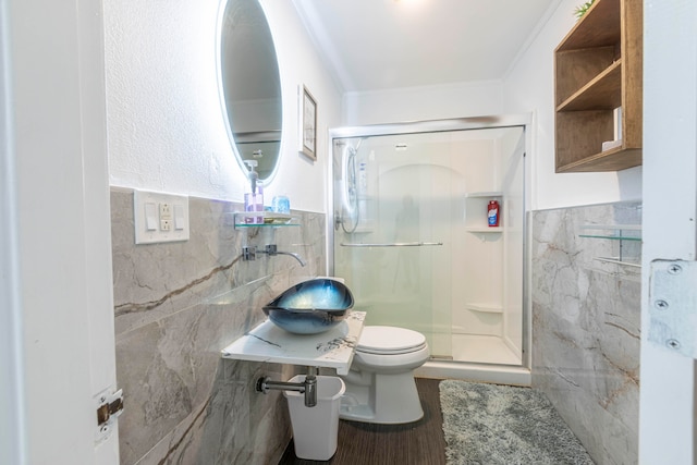 bathroom with sink, wood-type flooring, an enclosed shower, toilet, and tile walls