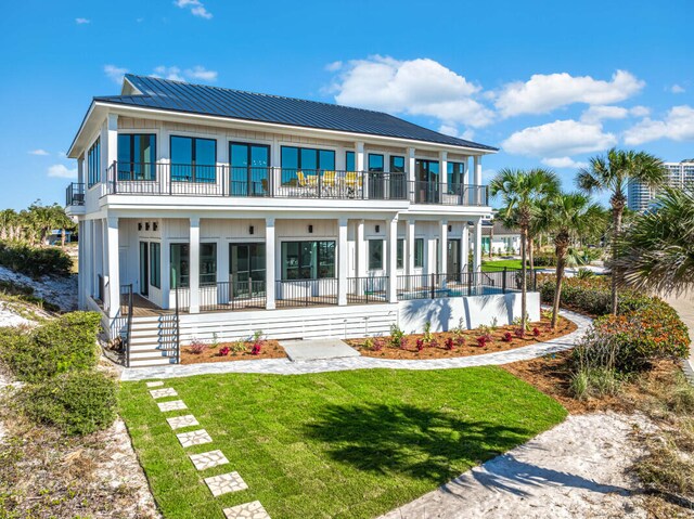 back of house featuring a balcony and a yard