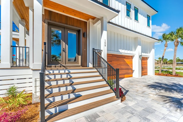 doorway to property with french doors, a porch, and a garage