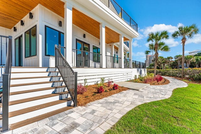 doorway to property with a lawn and a porch