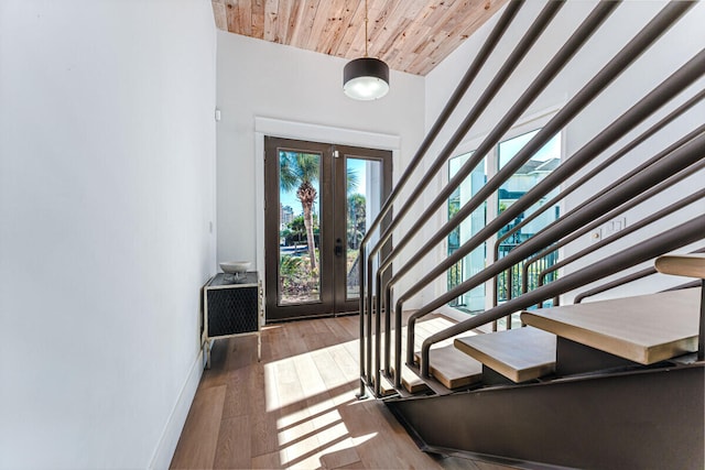 entrance foyer featuring hardwood / wood-style floors, wooden ceiling, a high ceiling, and french doors