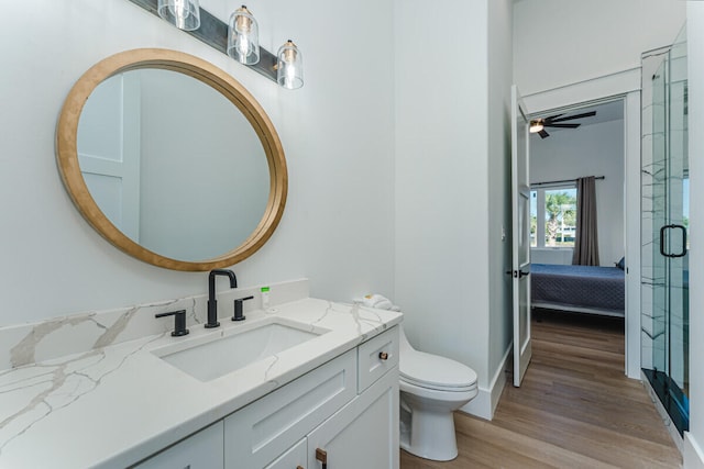 bathroom with an enclosed shower, vanity, ceiling fan, wood-type flooring, and toilet