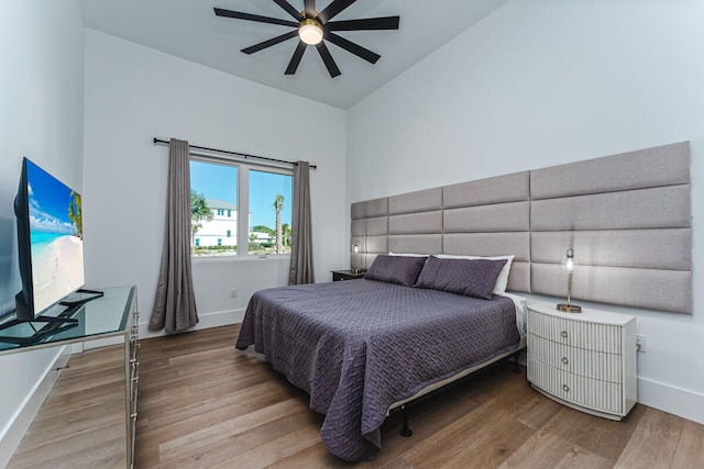 bedroom featuring hardwood / wood-style floors, ceiling fan, and lofted ceiling