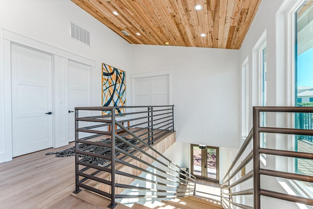 stairway featuring wood-type flooring, high vaulted ceiling, and wood ceiling