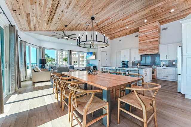 dining area featuring high vaulted ceiling, wooden ceiling, ceiling fan with notable chandelier, and light wood-type flooring