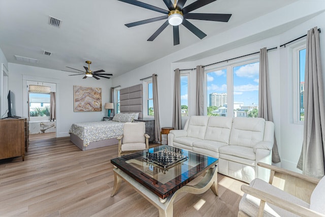 bedroom with light wood-type flooring, multiple windows, and ceiling fan