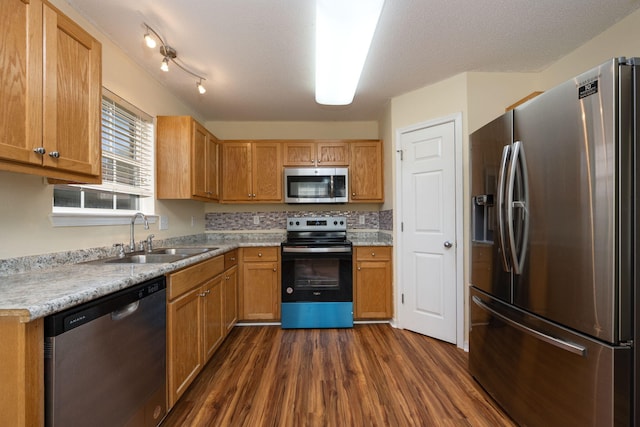 kitchen with a textured ceiling, stainless steel appliances, dark wood-type flooring, and sink