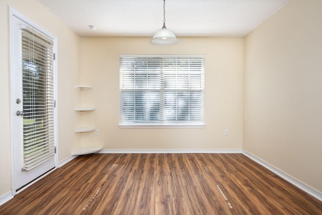 spare room with dark hardwood / wood-style flooring, a healthy amount of sunlight, and a textured ceiling