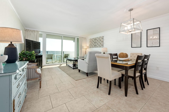 dining space featuring a wall of windows, light tile patterned floors, a chandelier, and ornamental molding