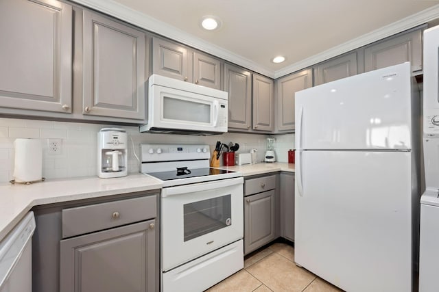 kitchen featuring light tile patterned floors, white appliances, tasteful backsplash, and gray cabinetry