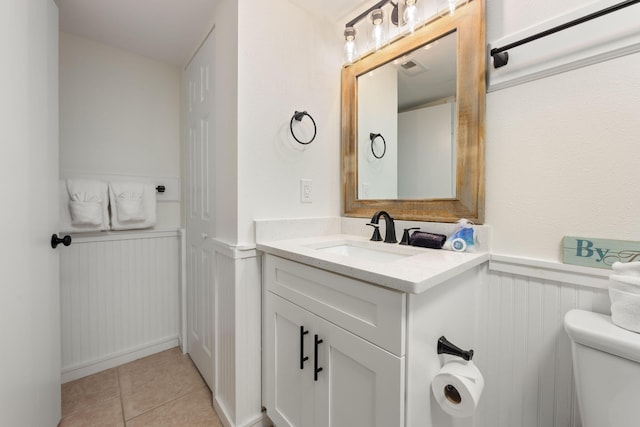 bathroom with tile patterned flooring, vanity, and toilet