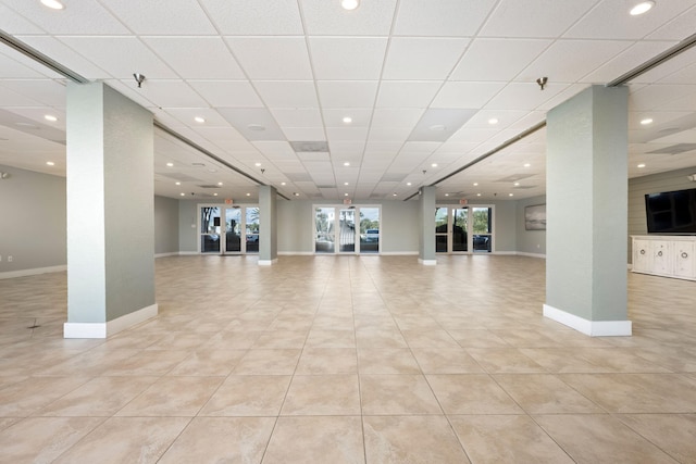 interior space featuring a paneled ceiling and light tile patterned flooring