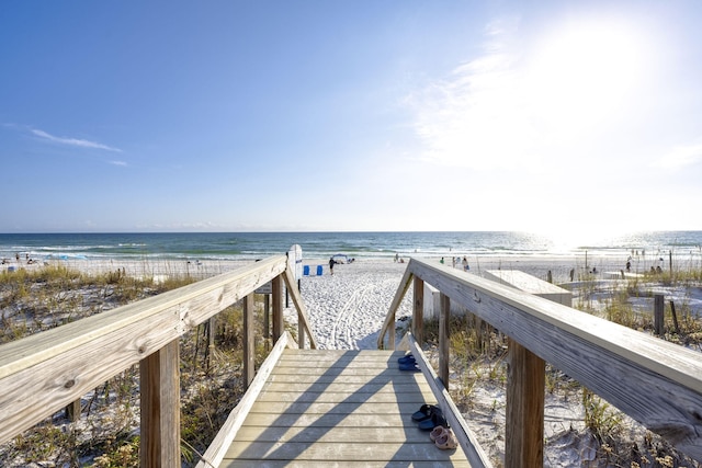 view of community with a water view and a beach view