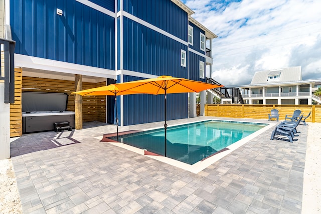 view of pool featuring a patio and a hot tub