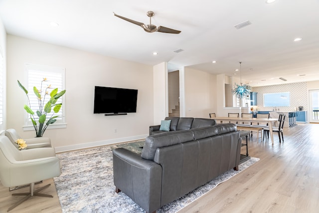 living room featuring ceiling fan and light hardwood / wood-style floors