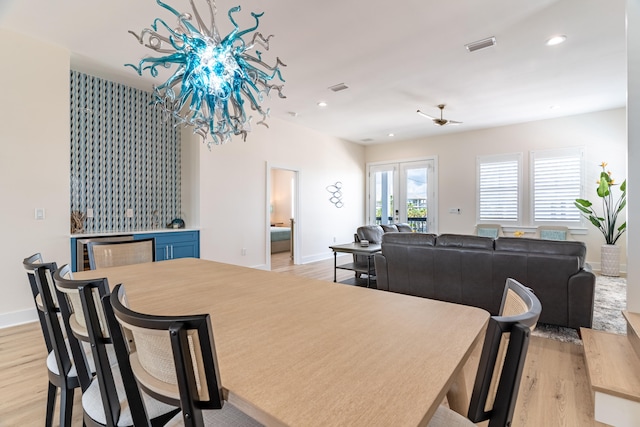 dining space with bar, light hardwood / wood-style floors, and ceiling fan