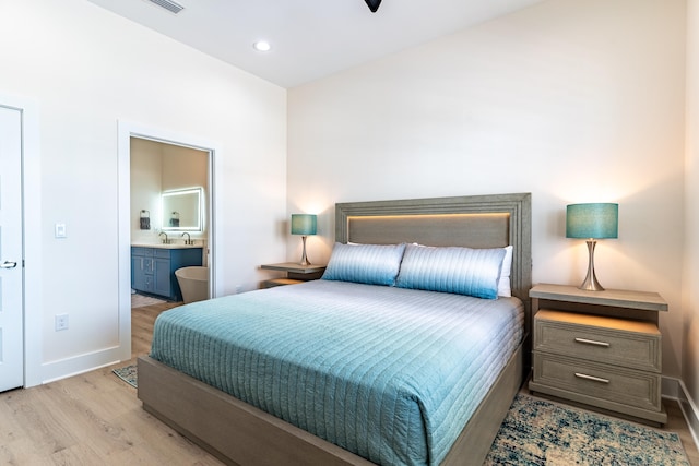 bedroom featuring light hardwood / wood-style floors and ensuite bath