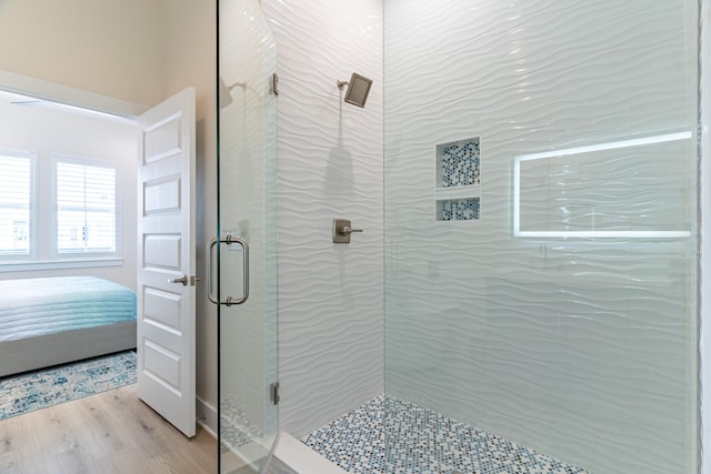 bathroom featuring a shower with door and wood-type flooring