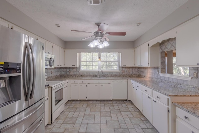 kitchen with backsplash, white cabinetry, sink, and stainless steel appliances