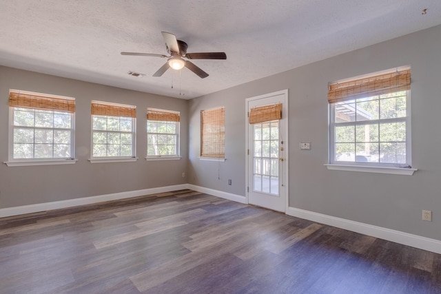 empty room with a textured ceiling, ceiling fan, and dark wood-type flooring