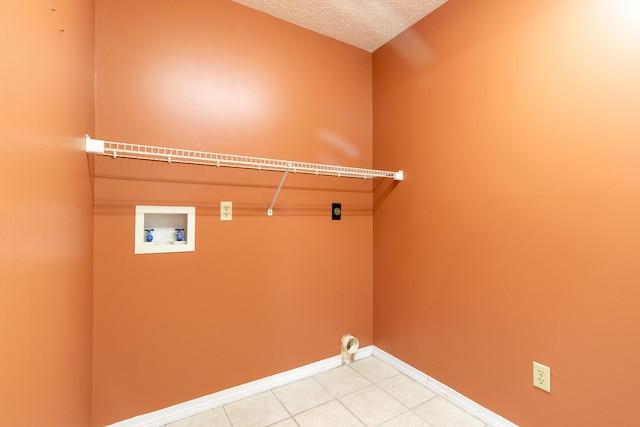 laundry room with hookup for a washing machine, light tile patterned floors, and a textured ceiling