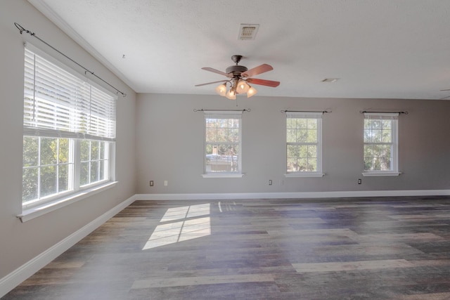 spare room with a wealth of natural light, dark hardwood / wood-style flooring, and ceiling fan