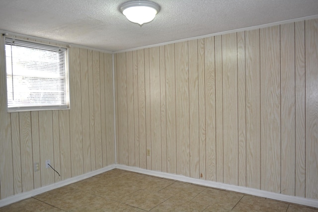 spare room featuring a textured ceiling and wooden walls