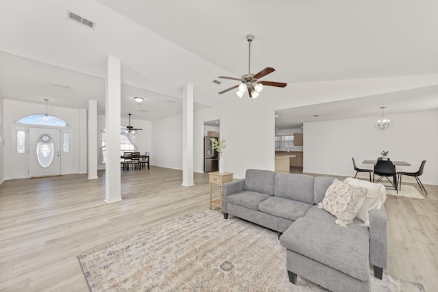 living room featuring high vaulted ceiling, light hardwood / wood-style floors, and ceiling fan with notable chandelier