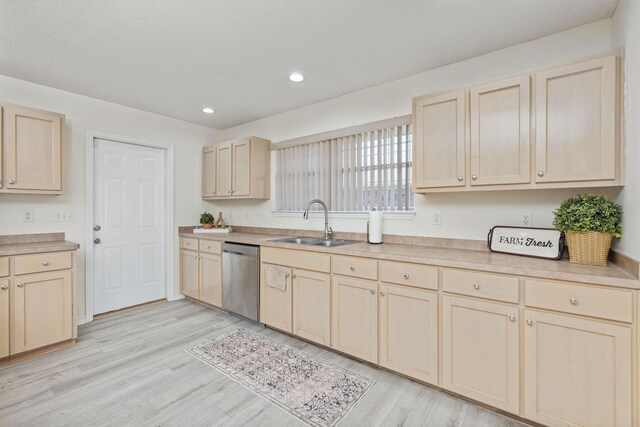 kitchen with light brown cabinets, dishwasher, sink, light hardwood / wood-style flooring, and a textured ceiling