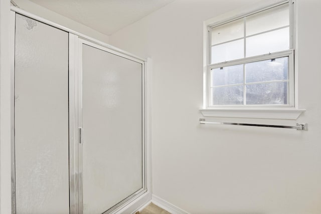 bathroom featuring a shower with door and a textured ceiling