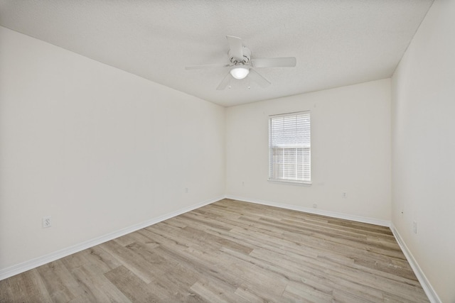 spare room featuring ceiling fan, light hardwood / wood-style flooring, and a textured ceiling