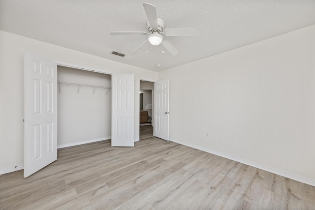 unfurnished bedroom featuring ceiling fan, a closet, light hardwood / wood-style floors, and a textured ceiling