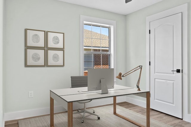 home office with light hardwood / wood-style flooring