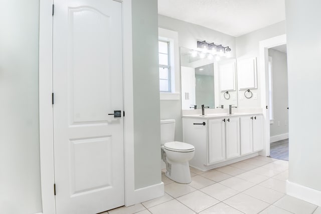 bathroom featuring tile patterned flooring, a textured ceiling, vanity, and toilet