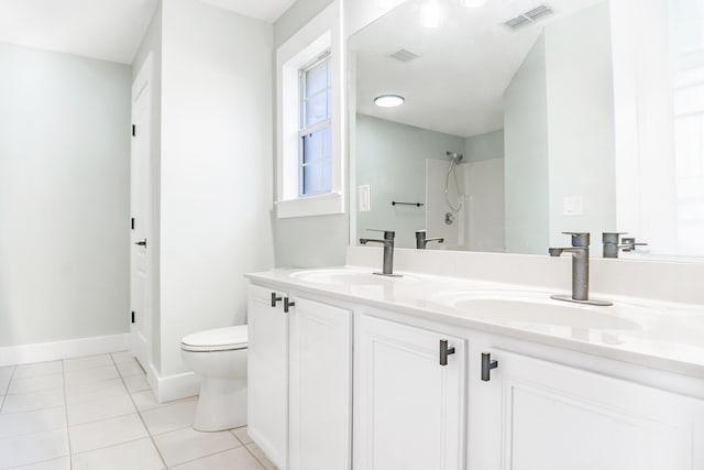 bathroom with tile patterned floors, vanity, toilet, and walk in shower