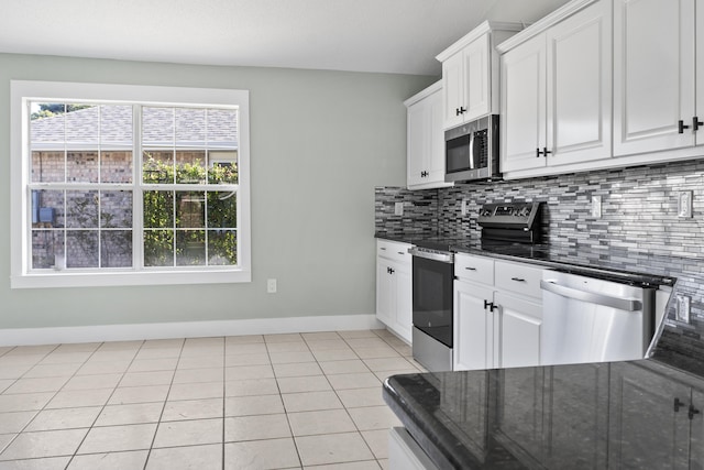 kitchen with tasteful backsplash, white cabinetry, light tile patterned floors, and appliances with stainless steel finishes