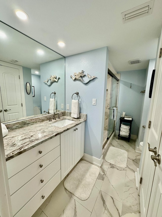 bathroom with vanity, an enclosed shower, and toilet