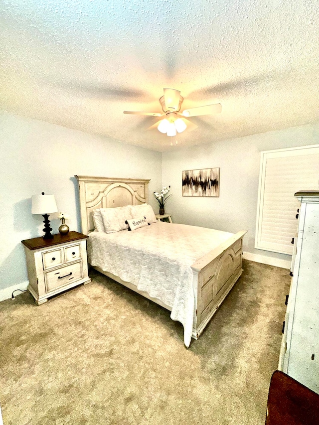 carpeted bedroom with ceiling fan and a textured ceiling