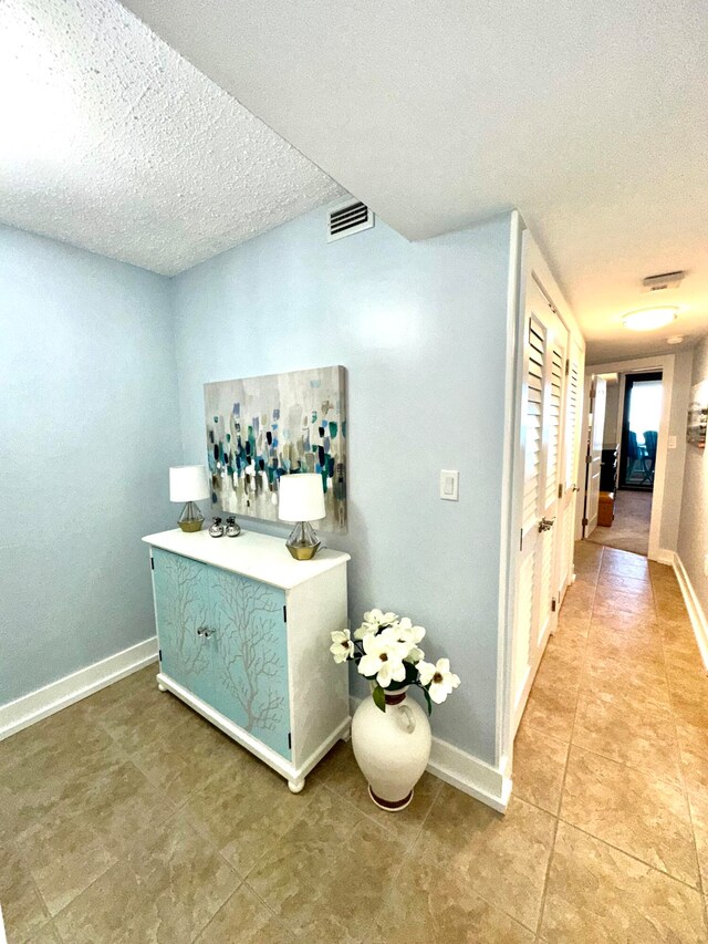 interior space with tile patterned flooring and a textured ceiling