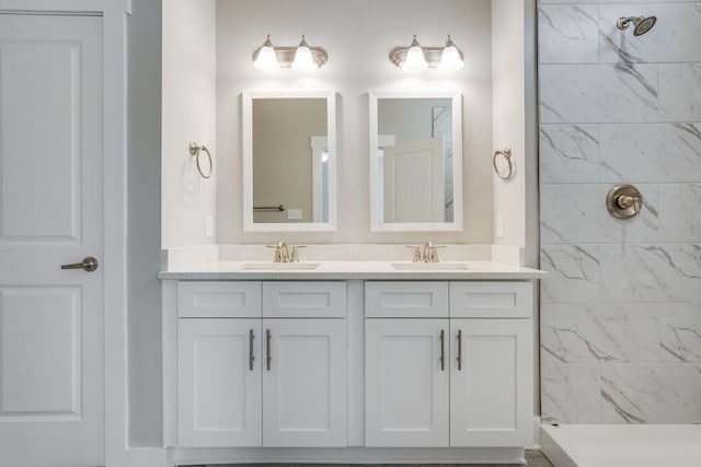 bathroom featuring tiled shower and vanity