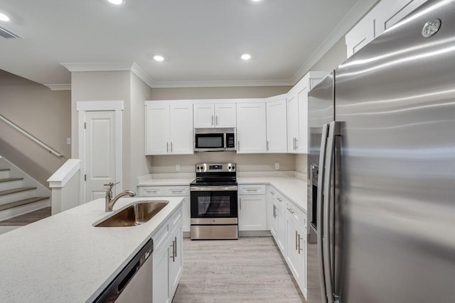 kitchen featuring stainless steel appliances, crown molding, sink, light hardwood / wood-style flooring, and white cabinetry