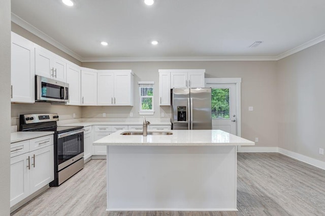 kitchen featuring white cabinets, appliances with stainless steel finishes, a kitchen island with sink, and sink